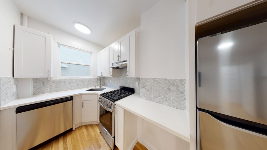 A modern kitchen with stainless steel appliances and white cabinets.